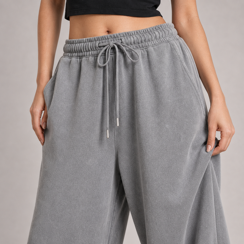 Close-up of washed-grey baggy jogger fabric, waistband and drawcord