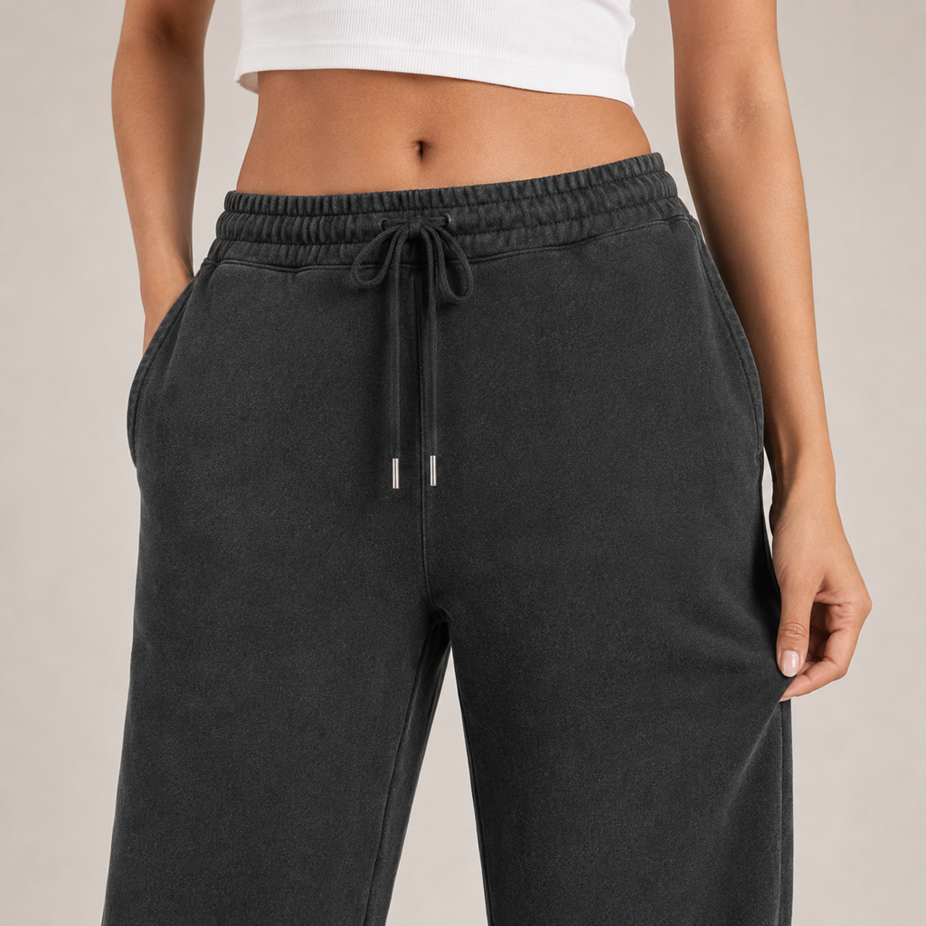 Close-up of washed-black jogger fabric, waistband, drawcord and pocket details