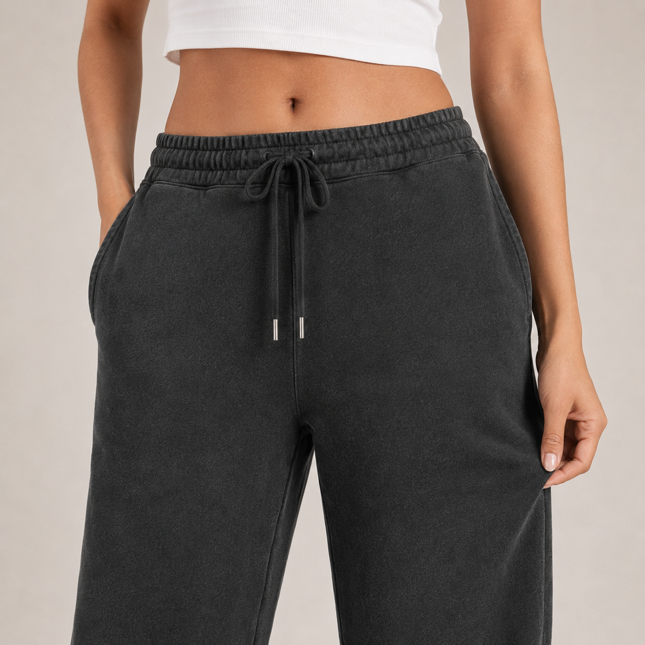 Close-up of washed-black jogger fabric, waistband, drawcord and pocket details